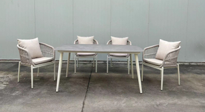 كرسي طعام من الحبال باللون البيج مع طاولة مستطيلة من الحجر الملبد